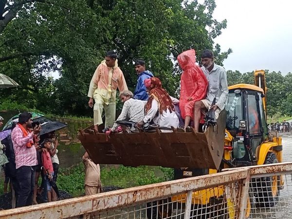 Pregnant woman cross the culvert from JCB Photo Goes Viral