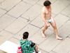 A Man in London walks down in a Street wearing a mask in place of underwear
