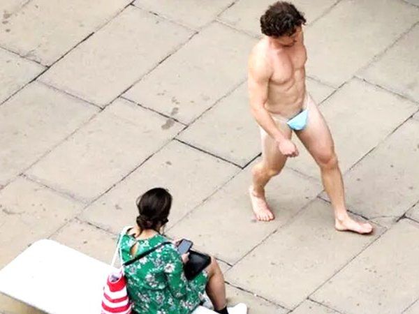 A Man in London walks down in a Street wearing a mask in place of underwear