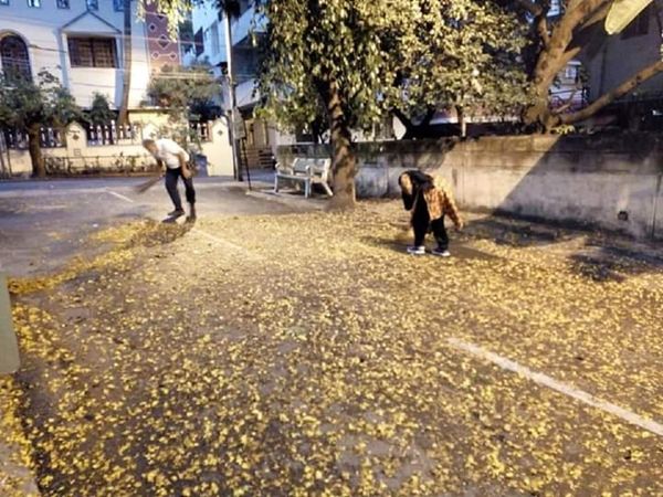 Minister sweeps outside the house with his wife