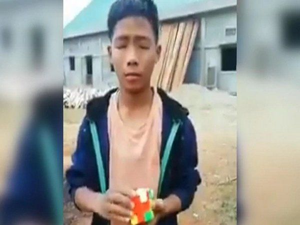 boy solving cube with eyes closed