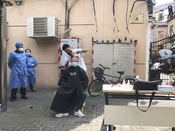 Shanghai slowly starts to reopen, residents gets haircuts and massages on the sidewalk 