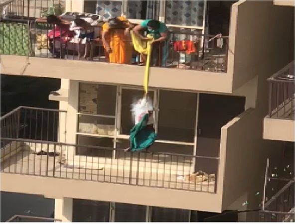Mother dangles child from 9th to 8th floor with a bedsheet to fetch fallen garment Watch Shocking Video