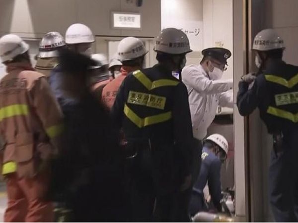 टोक्‍यो में ट्रेन स्‍टेशन पर जांच अधिकारी व इमरजेंसी वर्कर्स