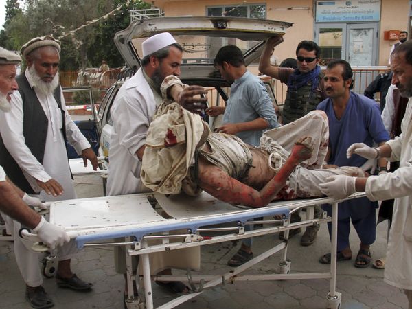 A wounded man is brought by stretcher into a hospital after a mortar was fired by insurgents in Haskamena district of Jalalabad east of Kabul, Afghanistan, Friday, Oct. 18, 2019.